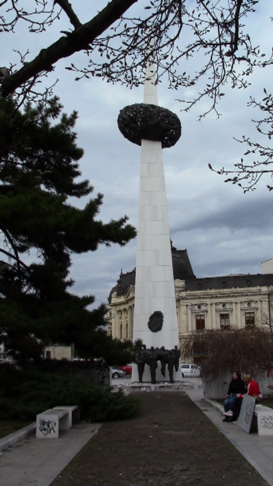 Often vandalised. Locally called the potato. Supposed to symbolise democracy piercing through the turmoil and despair of the people. Not a popular piece.